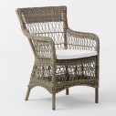 Fauteuil en résine tressée avec un coussin blanc crème