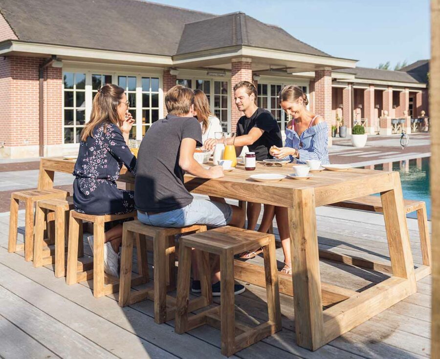 Repas convivial autour d'une table en teck recyclé